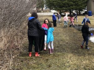 groupe d'enfants et adulte ramassent déchets sur la pelouse